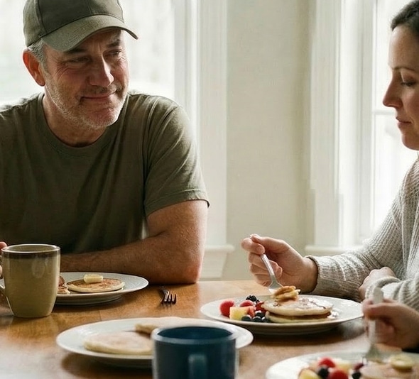 Man and woman share breakfast together at a table by a window